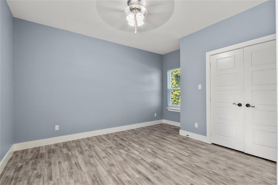 Unfurnished bedroom featuring ceiling fan, a closet, and light hardwood / wood-style floors