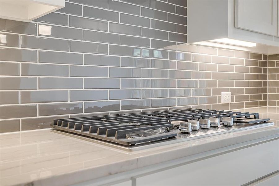 Room details featuring white cabinets and tasteful backsplash