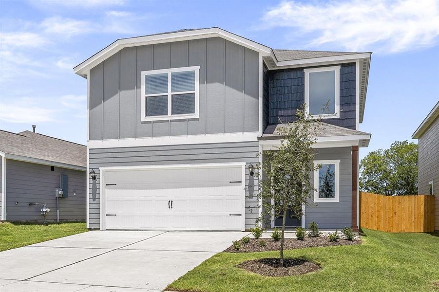 View of front of property with a garage and a front lawn