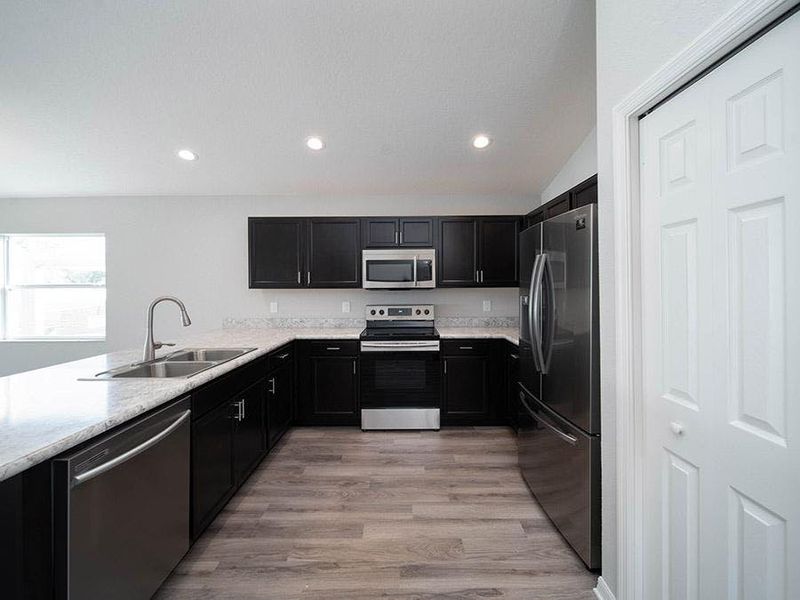 Sunny and open kitchen with pantry, counter-height bar, and your choice of finishes - Amaryllis home plan by Highland Homes