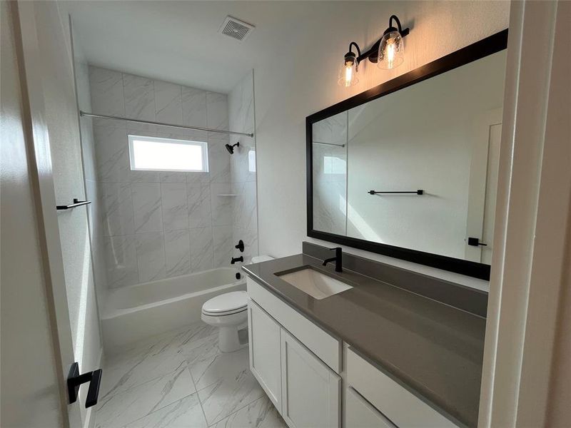 Guest bath with tile to the ceiling and framed mirror