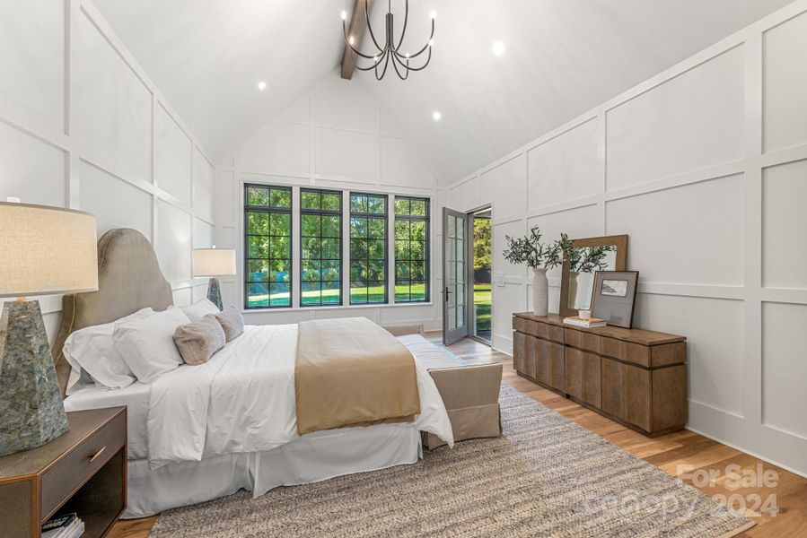 Sun-drenched primary bedroom with access to the screened porch and views of the expansive back yard.