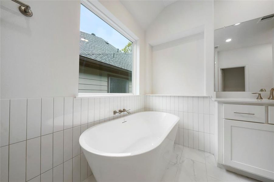 The Primary Bath stand-alone tub is surrounded by Emser Tile. (Sample photos of a completed Chesapeake floor plan. The image may feature alternative selections and/or upgrades.)