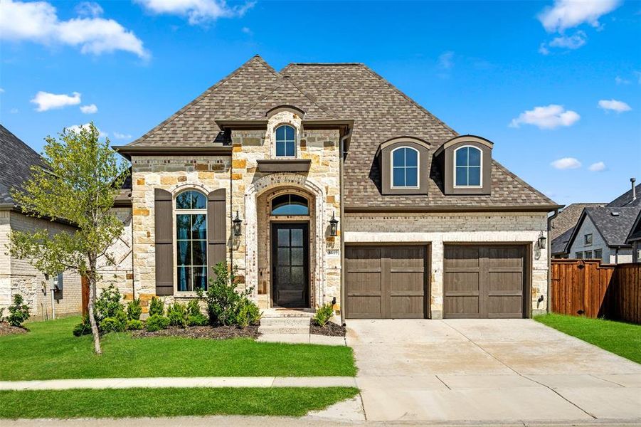 French country style house with a garage and a front yard