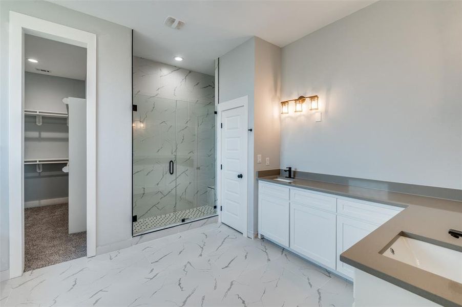 Bathroom with vanity and a shower with shower door