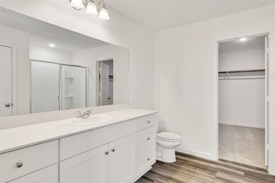 Bathroom with walk in shower, vanity, hardwood / wood-style floors, and toilet