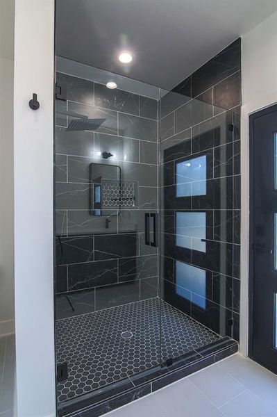 Bathroom with tile patterned flooring and a shower with shower door