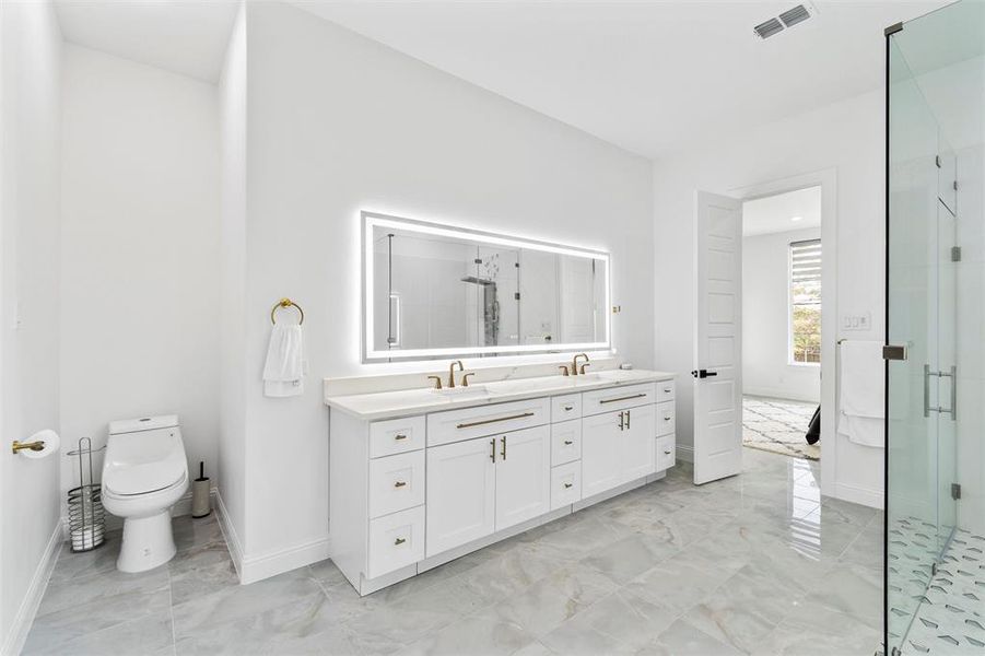 Bathroom featuring a shower with door, vanity, and toilet