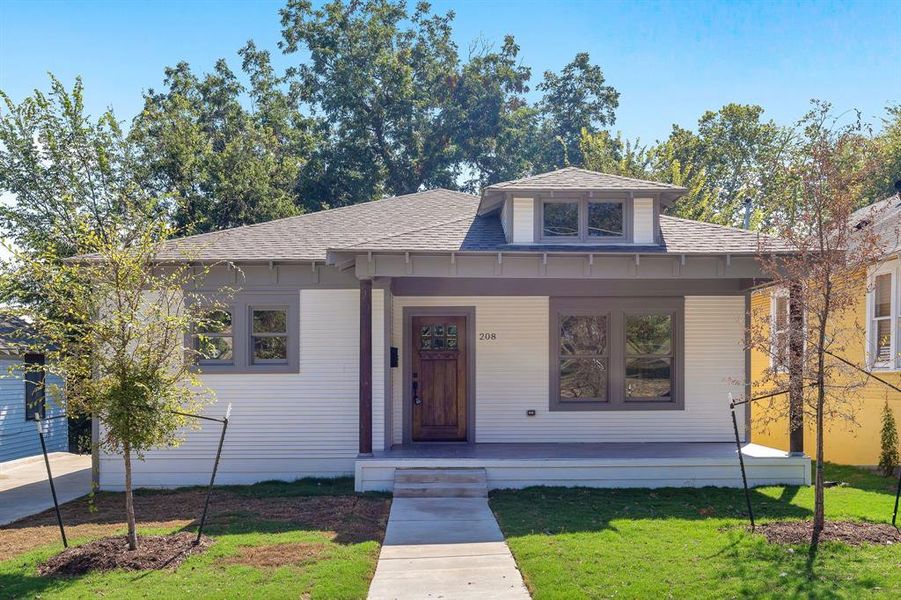 View of front of home featuring a front yard and covered porch