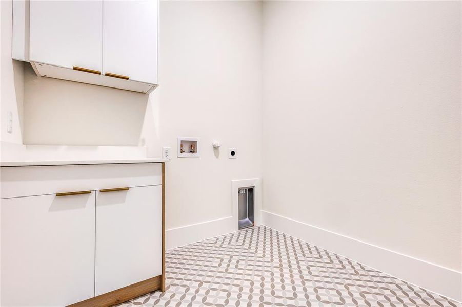 Clothes washing area featuring light tile patterned flooring, hookup for an electric dryer, gas dryer hookup, and hookup for a washing machine