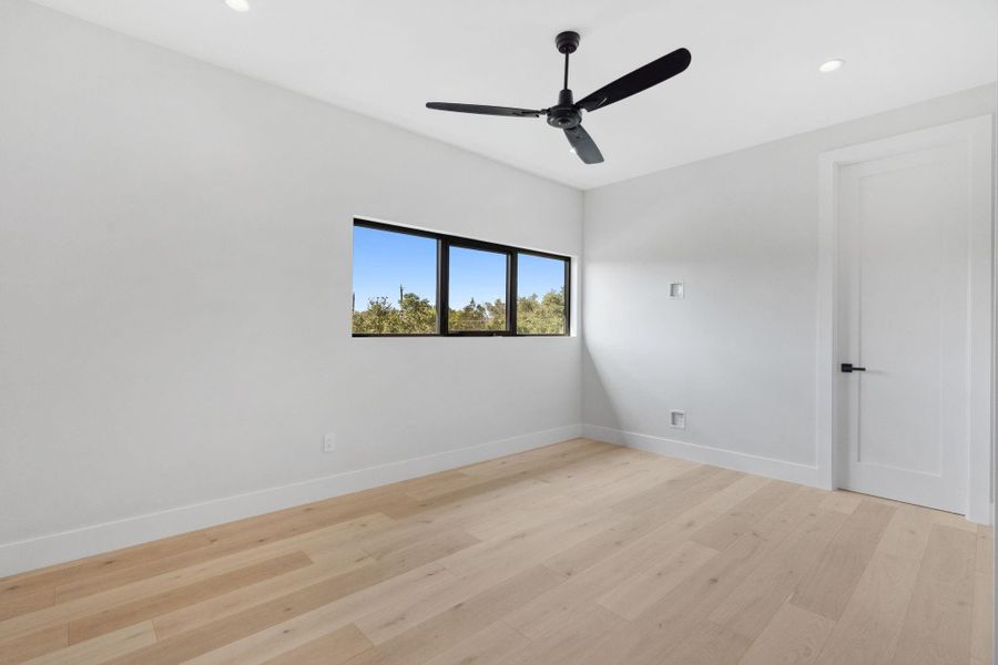 Light-filled fourth bedroom with ample closet space, connected to a Jack-and-Jill bathroom offering private vanities and a shared shower.