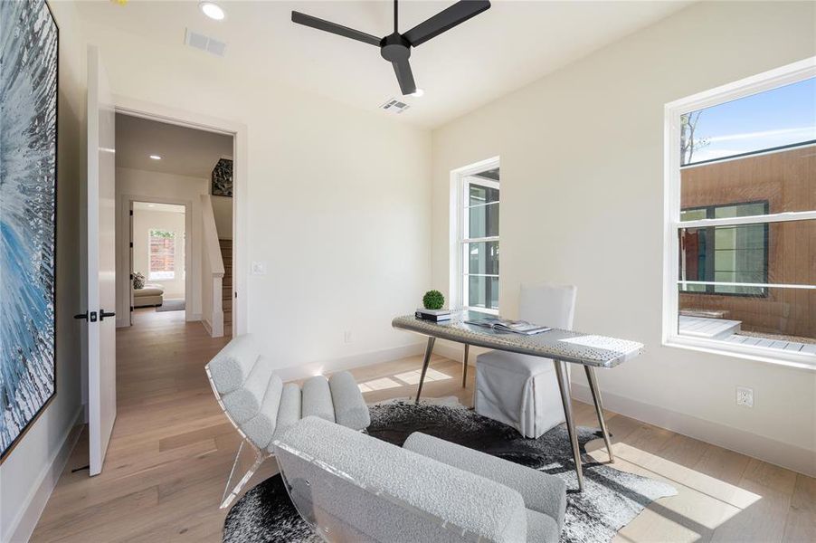 Office with light wood-type flooring and ceiling fan