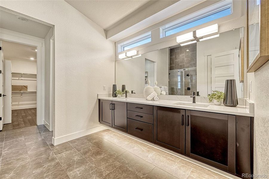 The private en-suite bathroom offers tile flooring and a floating double vanity with plenty of cabinetry.