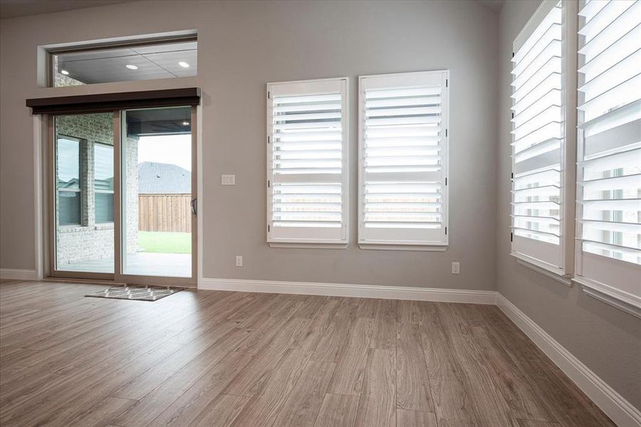 Unfurnished room featuring hardwood / wood-style floors and plenty of natural light