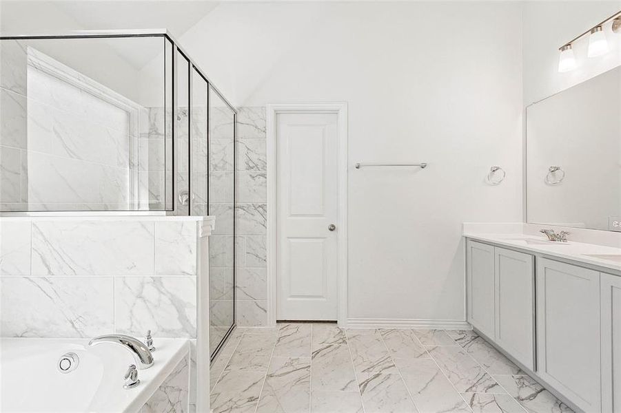 Bathroom with tile patterned floors, shower with separate bathtub, and vanity