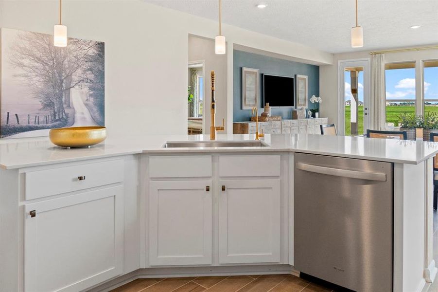 From this kitchen island, you are able to gather the family together in good conversation. The kitchen island features pendant lighting, stained cabinets for extra storage, SS dishwasher, silestone countertop, and an extended counter space.