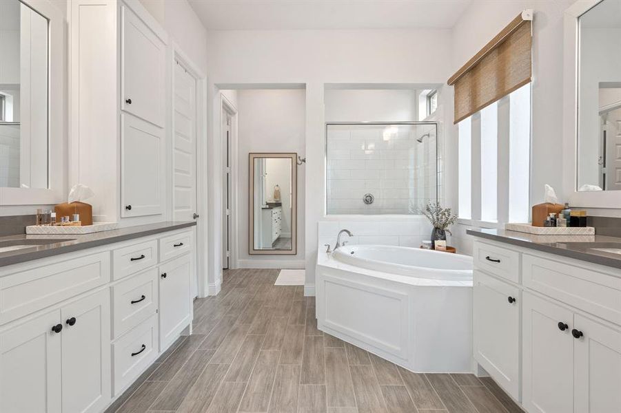 Bathroom featuring vanity and separate shower and tub