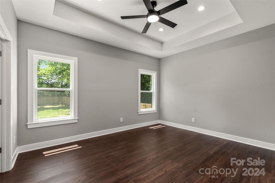 Primary Bedroom with recessed lighting and tray ceiling