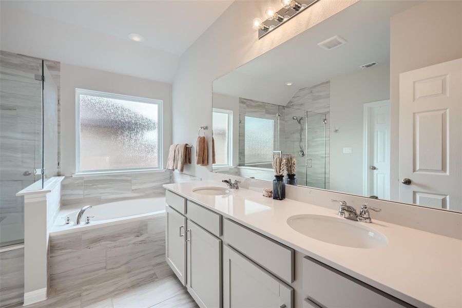 This primary bathroom has it all!!  A soaking tub, walk-in shower, and double vanities.  This well-appointed bathroom is modern, warm and calming and a great place to get ready for the day or unwind in solitude.