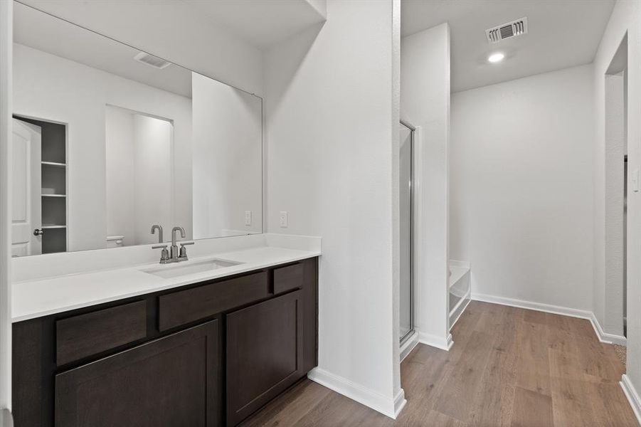 Bathroom with walk in shower, oversized vanity, and wood-style floors