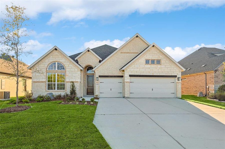 View of front of property with a garage, a front yard, and central air condition unit