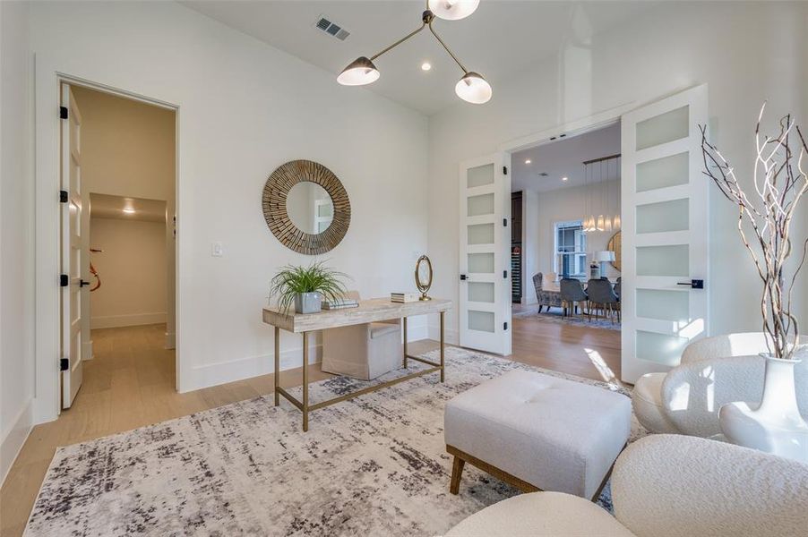 Home office with built in features and light hardwood / wood-style floors