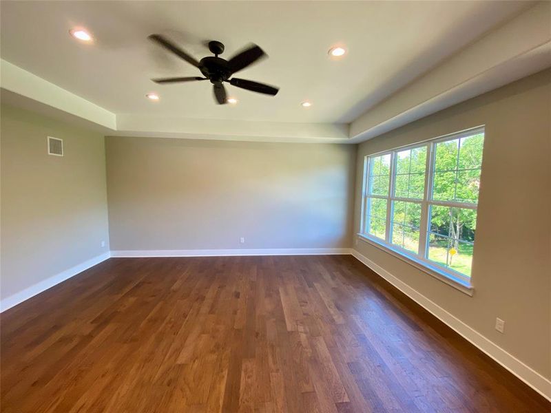 Spare room featuring dark wood-type flooring and ceiling fan