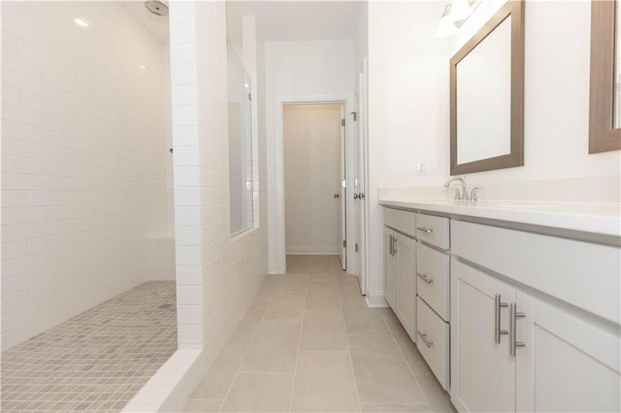 Primary bathroom with double vanity and the extended shower with drying area. **Photo not of actual home, for representation purposes only. **