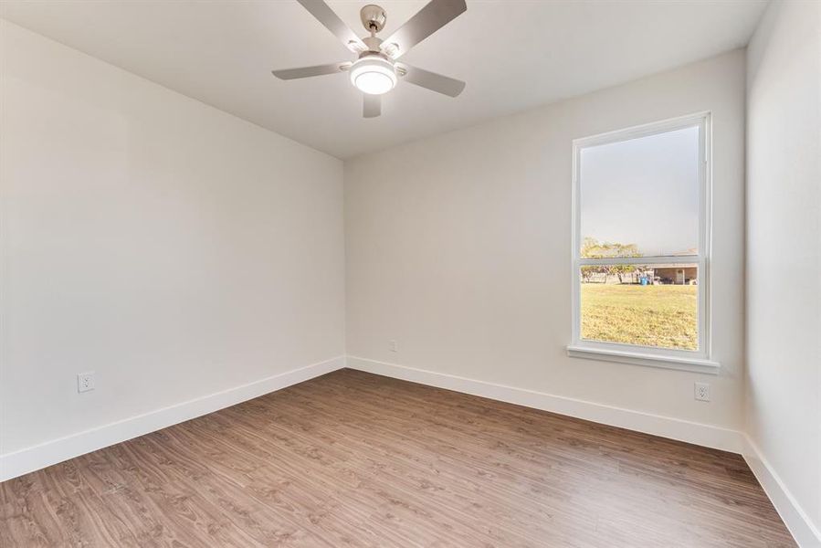 Empty room featuring wood-type flooring and ceiling fan