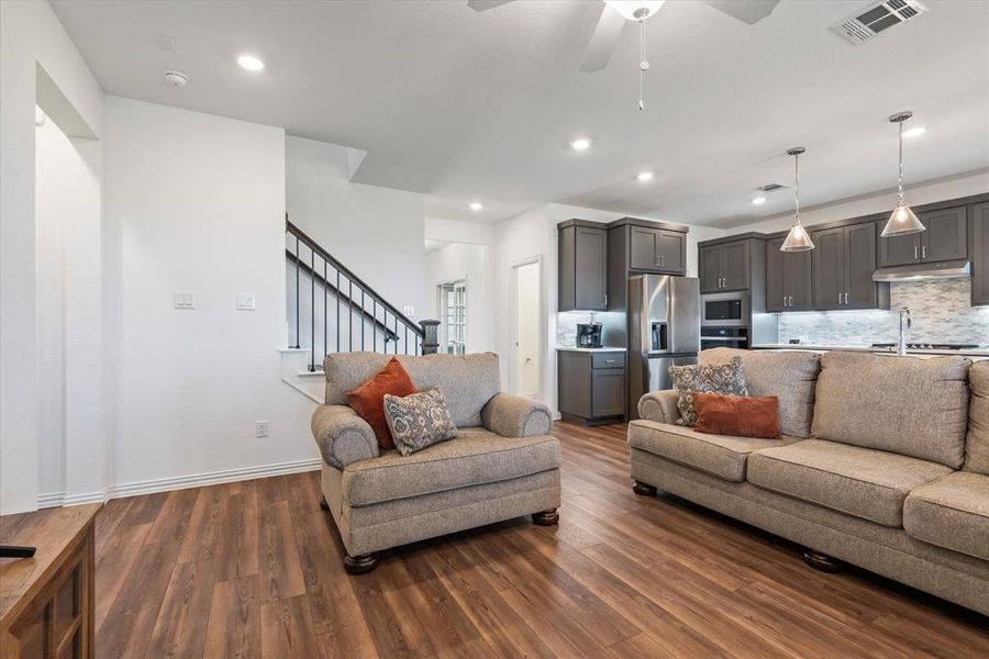 Living room with dark hardwood / wood-style floors, sink, and ceiling fan