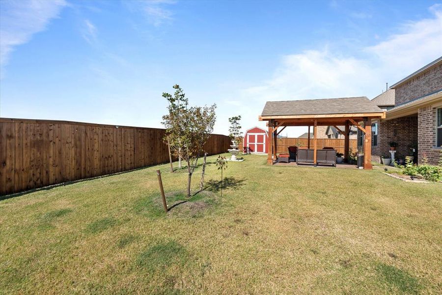 View of yard featuring a patio area, a storage unit, and an outdoor hangout area