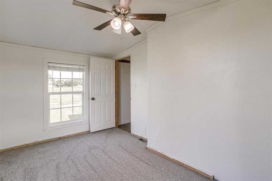 Carpeted spare room with lofted ceiling and ceiling fan