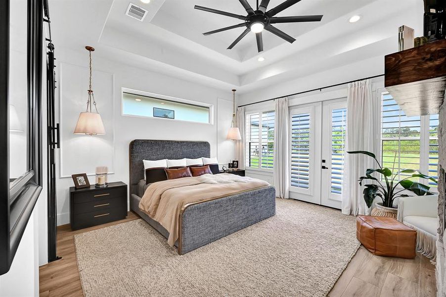 Primary bedroom with planation shutters and continuous tile flooring throughout.