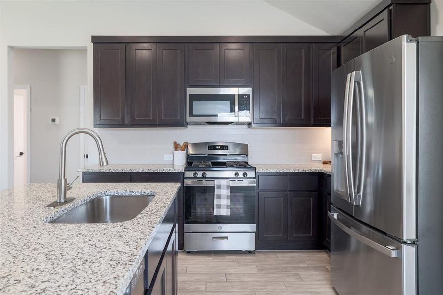 Stainless-steel appliances, including a gas range, ensure a high-end cooking experience.