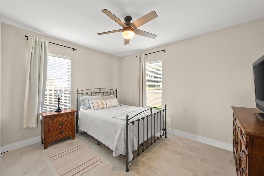 Bedroom with ceiling fan and light tile floors