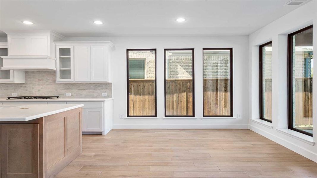 Kitchen featuring white cabinets, plenty of natural light, and light wood-type flooring