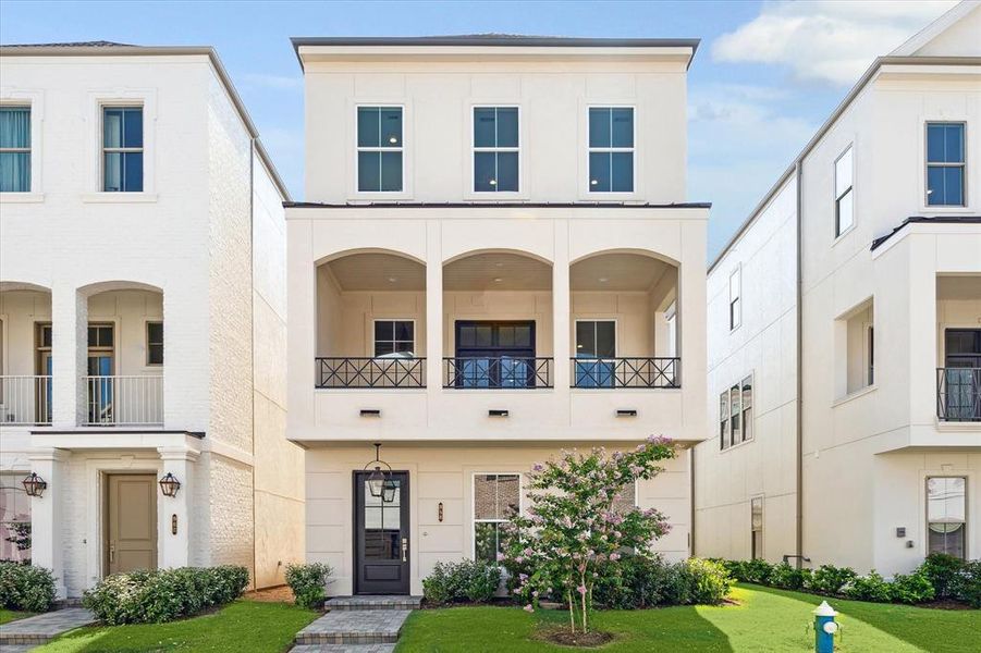 Inside the Guard Gated Houston Community inside the Loop is a 3 story Pelican Builder Built home with an Elevator shaft and outdoor living with green grass in the front of the home.