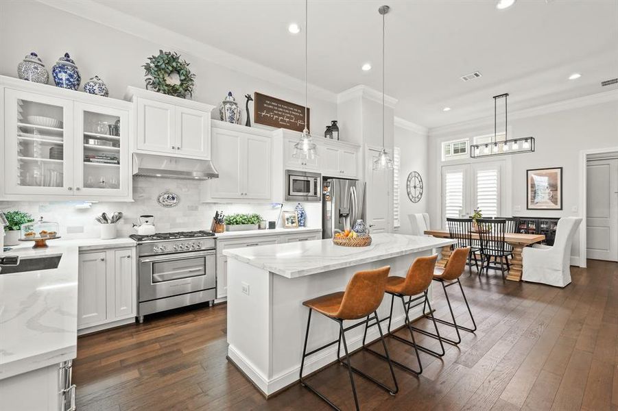 The kitchen also features engineered wood floors, recessed lighting, a breakfast bar, and easy access into the dining room.