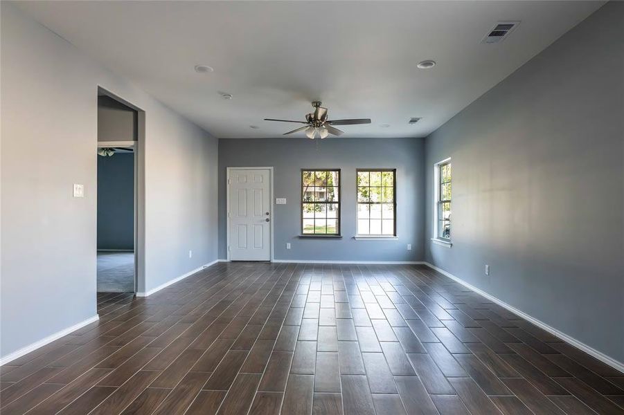 Empty room with dark hardwood / wood-style flooring and ceiling fan