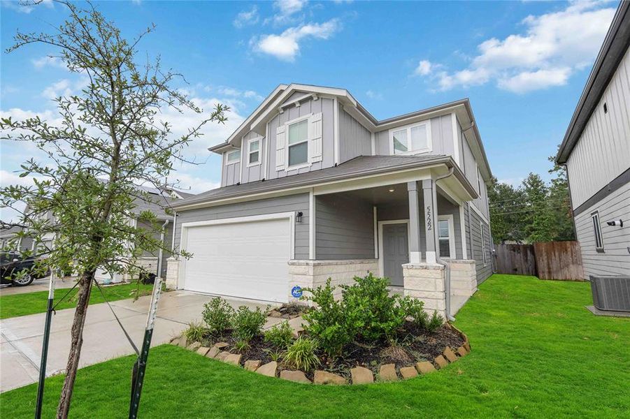 Side view of home showcasing manicured landscaping and front porch.