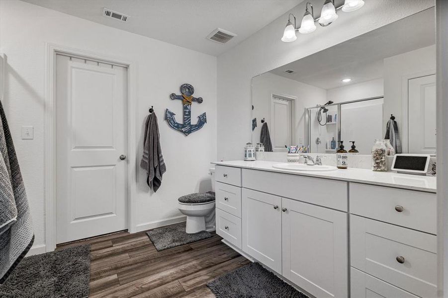 Bathroom with vanity, walk in shower, hardwood / wood-style flooring, and toilet