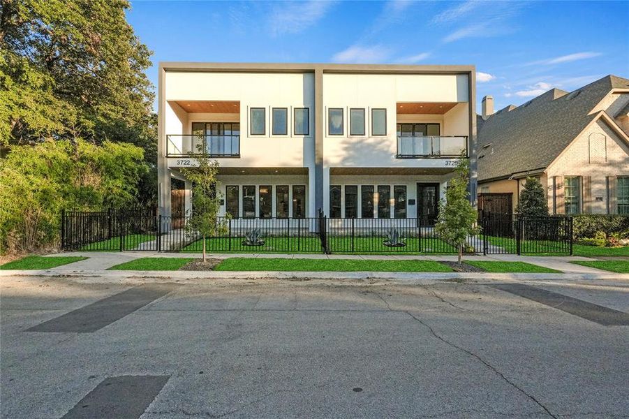 View of front of property featuring a balcony and a front lawn