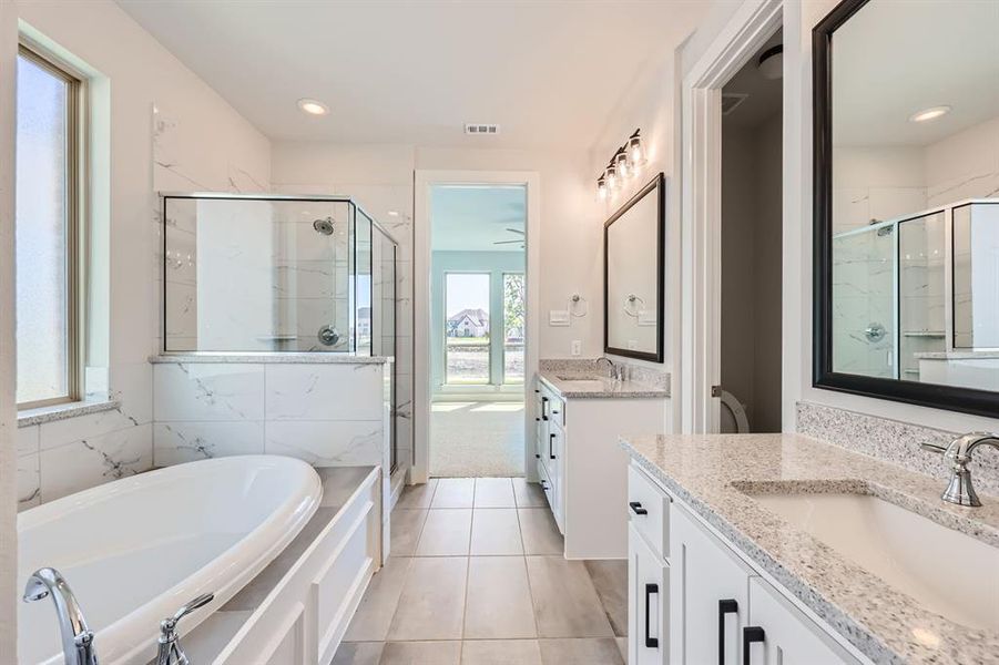 Bathroom featuring separate shower and tub, tile patterned flooring, and double sink vanity