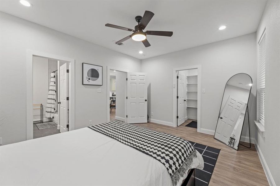 Bedroom with ceiling fan, light hardwood / wood-style flooring, a closet, a walk in closet, and ensuite bath