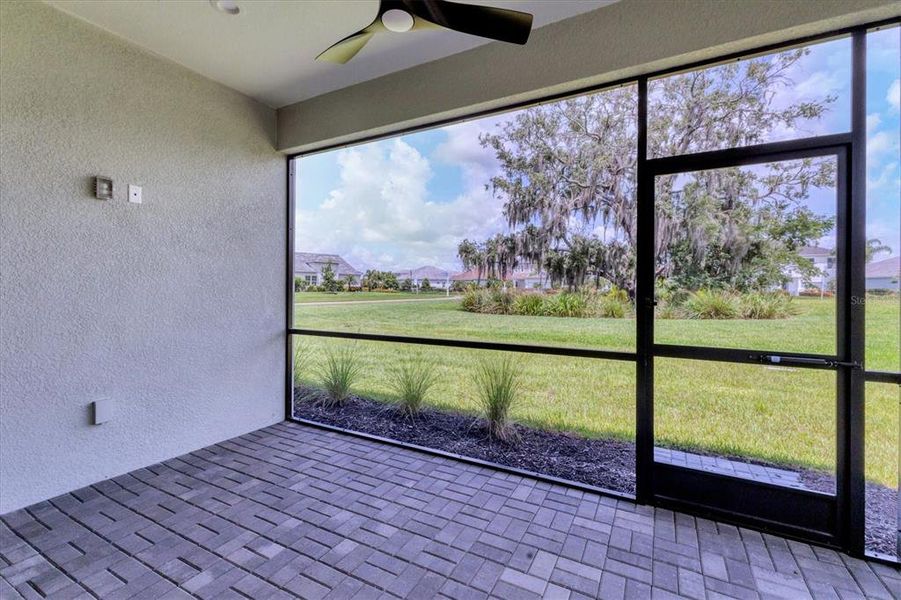 Screened lanai with ceiling fan to private yard.