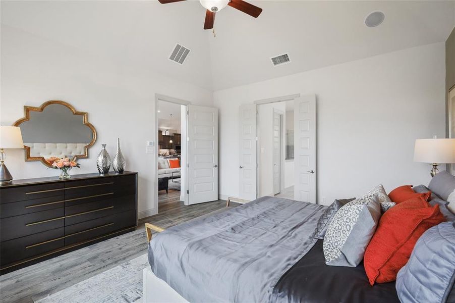 Bedroom with light wood-type flooring, high vaulted ceiling, and ceiling fan