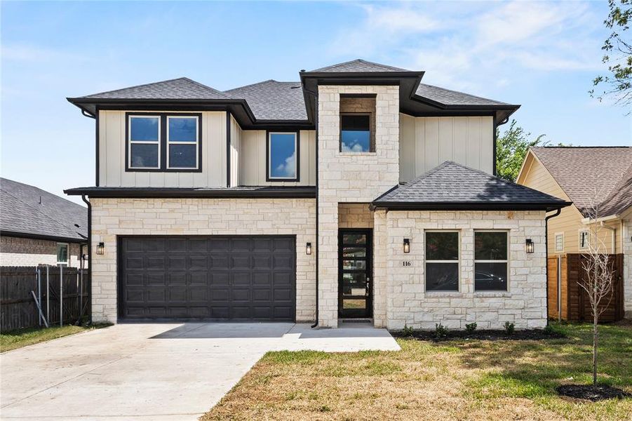 View of front of house with a garage and a front lawn