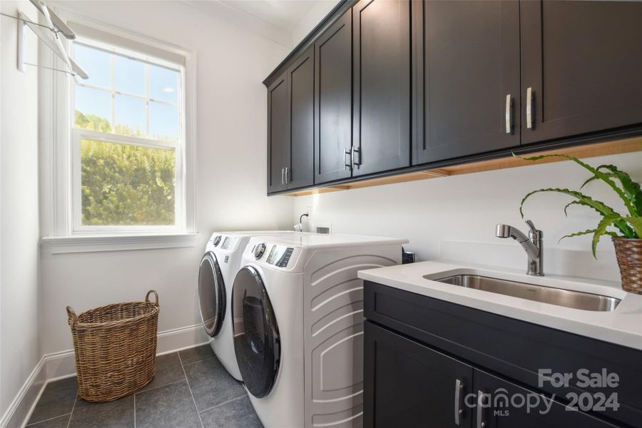 Laundry room with a sink and a generous amount of cabinets for storage.