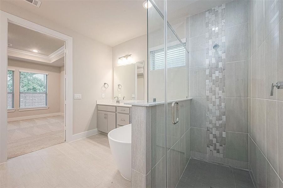 Unwind in this spa-like bath, featuring an oversized shower, freestanding tub, and double vanities.