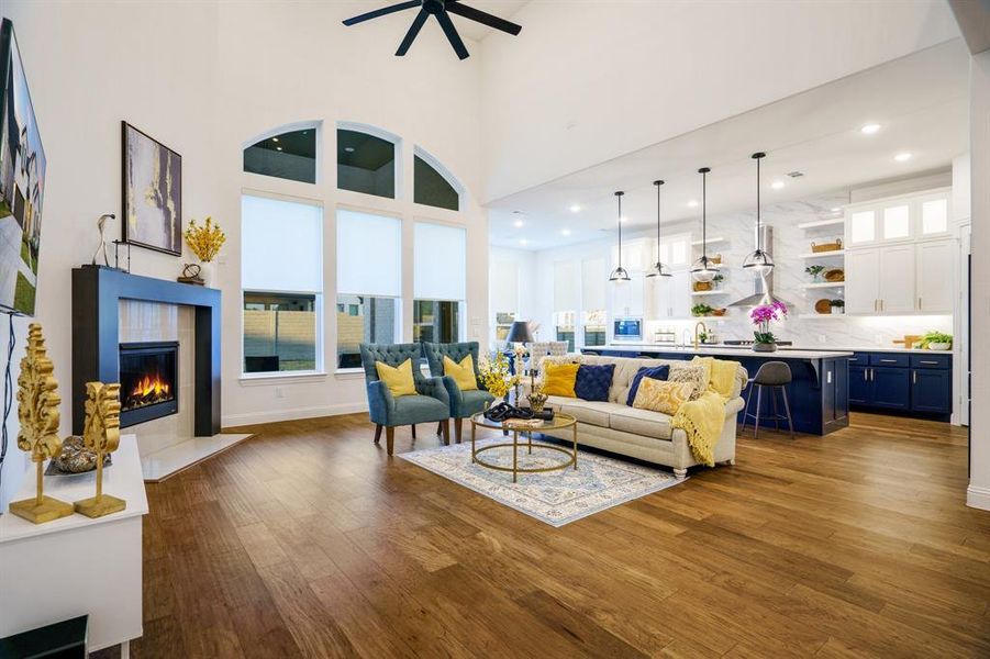 Living room with a high ceiling, dark hardwood / wood-style floors, and ceiling fan